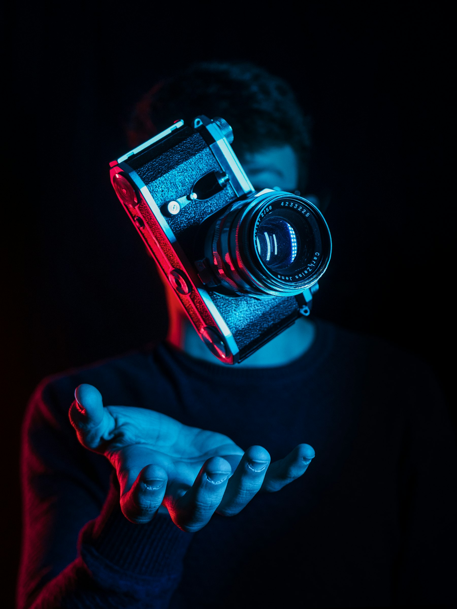 Professional camera and lens photographed in warm studio light